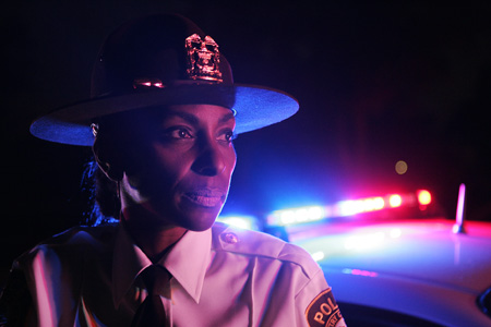 Country Club Hills Police Chief Regina Evans  watches her oficers search through a suspects automobile for narcotics during Operation Clean-Sweap, an aggressive measure by police to rid the  Friday  July 17, 2009. Chief Evans is the first female police chief in Country Club Hills.  (Tim Hunt for the Chicago Tribune)MET