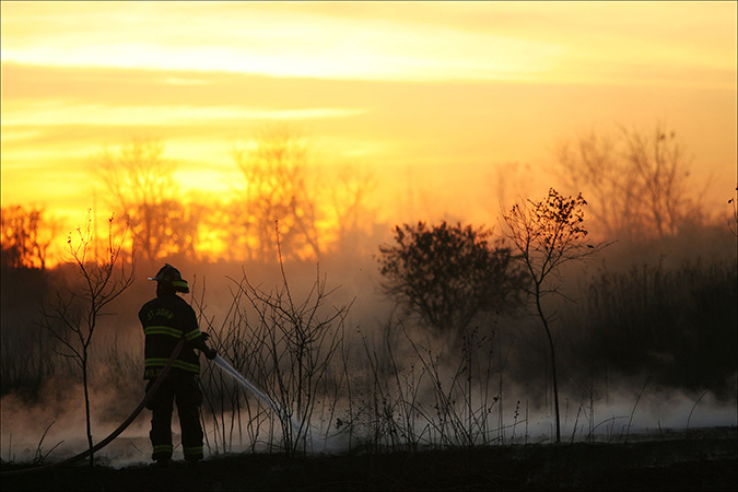 A firefighter from St John, works to extinguish a still smoldering field after a brush fire broke out the day before off Clark road in Crown Point, that remained smoldering from the day before, Thursday Oct 21, 2010.  Several departments assisted in the effort including Lake Hills, Crown Point, Merrillville, Cedar Lake, St John, Four Seasons, Lake Ridge, and Hanover Township.